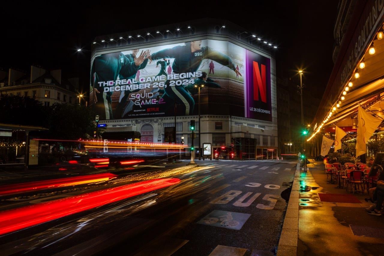 Toile événementielle XXL déployée sur une façade parisienne de nuit