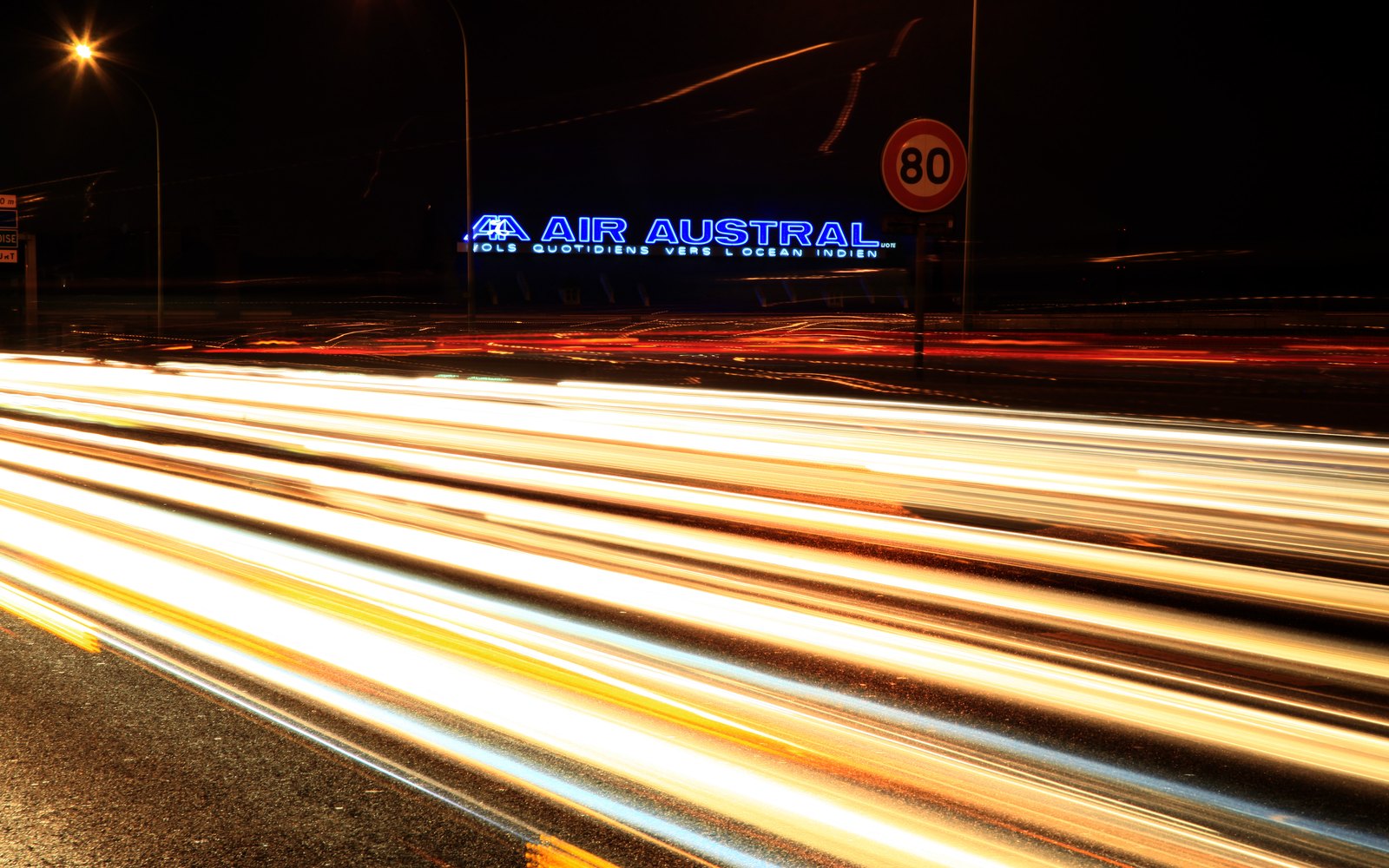 Enseigne lumineuse Air Austral la nuit, avec traînées lumineuses